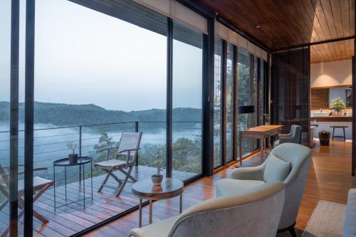 a living room with large windows and a view of the ocean at Glenross Living - A Collection of 7 Private Pool Villas and 3 Colonial Suites in Kalutara