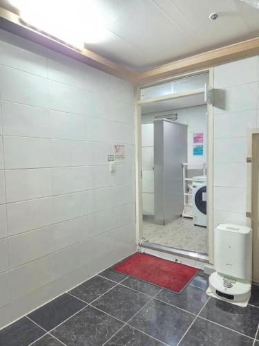 a bathroom with a toilet and a red rug at Raon House Paju in Paju