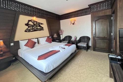 a bedroom with a large bed in a room at Ruean Phae Royal Park Hotel in Phitsanulok