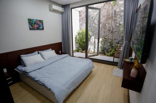 a bedroom with a bed and a large window at Xanh Homestay in Da Nang