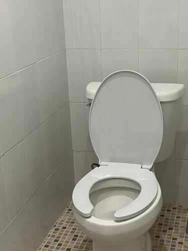 a bathroom with a toilet with the lid up at Vistalmar House in Isla Mujeres