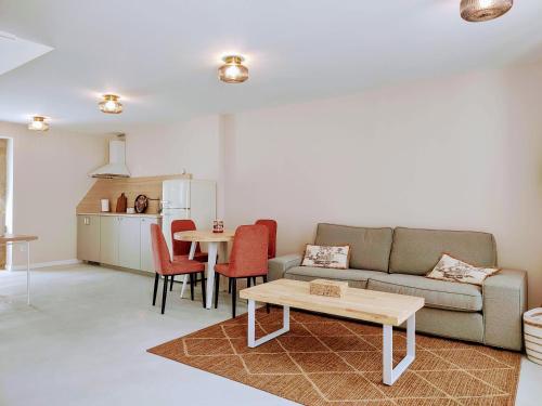 una sala de estar con un sofá y una mesa en Casa jardín, en Laxe