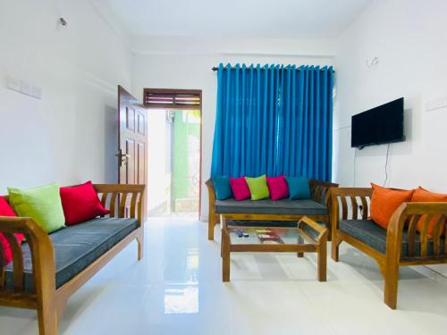 a living room with two couches and a flat screen tv at TK Homes in Badulla