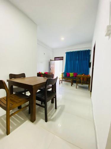 a dining room with a wooden table and chairs at TK Homes in Badulla