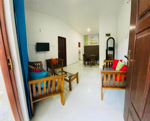 a living room with chairs and a couch and a table at TK Homes in Badulla