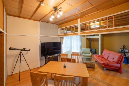 a living room with a table and a couch at 大切なペットと一緒に泊まれる一棟貸し in Sado