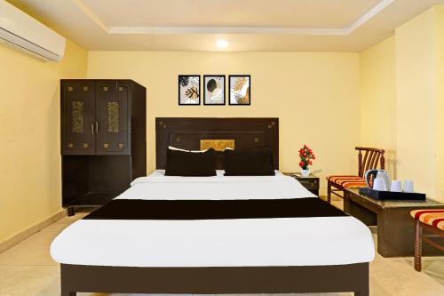 a bedroom with a large bed and a desk at Collection O Kurnool Formerly Sai Priyanka Inn in Kurnool
