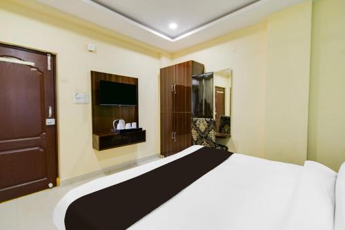 a bedroom with a large bed and a tv at Super Townhouse Hitech City Madhapur in Hyderabad