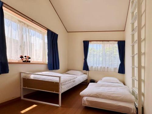 a bedroom with two beds and a window at スペース海浜幕張ハウス in Chiba