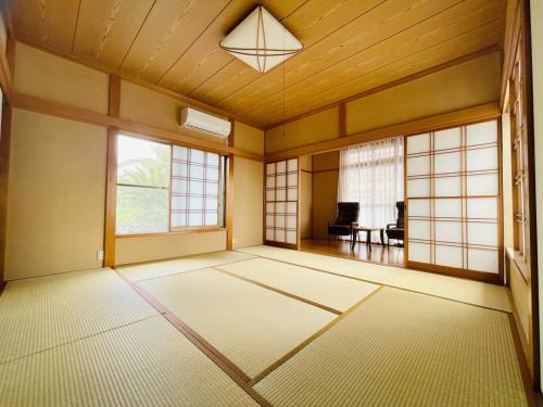 an empty room with a table and windows at TheOceanVilla Mare in Oshima
