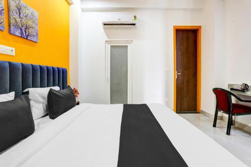 a bedroom with a large bed and a table at Super Townhouse Sector 69 Gurgaon in Gurgaon