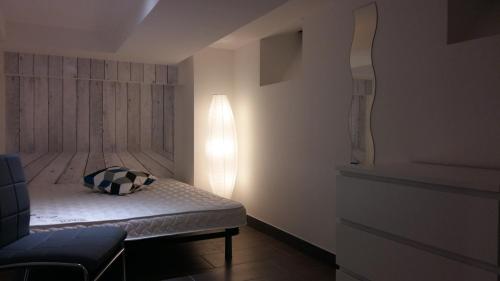 ein kleines Schlafzimmer mit einem Bett und einer Lampe in der Unterkunft Tripiers Duplex in Colmar