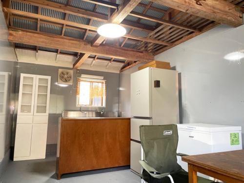 a kitchen with a white refrigerator and a table at TheOceanVilla Mare in Oshima