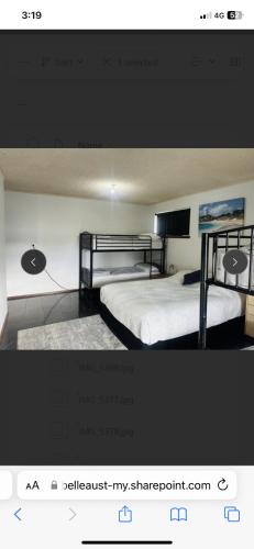 a bedroom with two beds and a tv on the wall at LingaLonga in Busselton