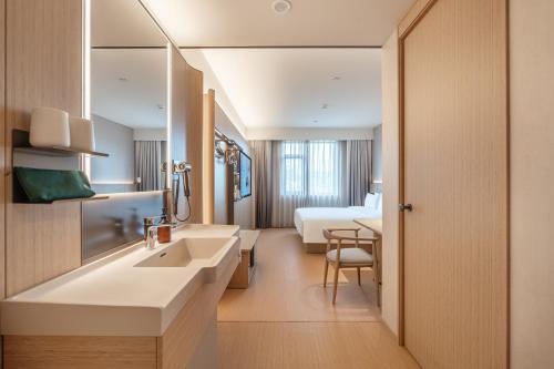 a bathroom with a sink and a bed in a room at JI Hotel Beijing Qianmen Tianqiao Subway Station in Beijing