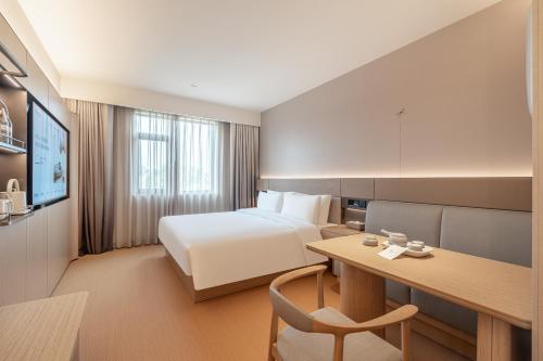 a hotel room with a bed and a desk at JI Hotel Beijing Qianmen Tianqiao Subway Station in Beijing