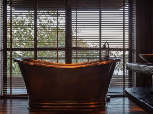 a bath tub in front of a window with a view at Kavya Himalayas in Nagarkot