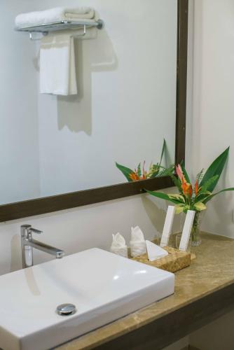 a bathroom with a white sink and a mirror at Balai Adlao in El Nido