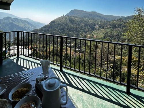a table on a balcony with a view of mountains at New Ella Nature View in Ella