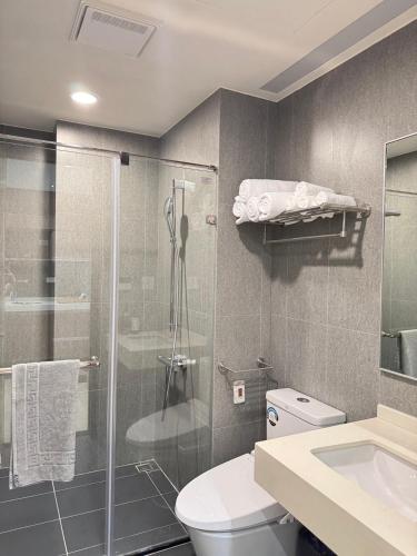 a bathroom with a shower and a toilet and a sink at 留亦晚 in Toucheng