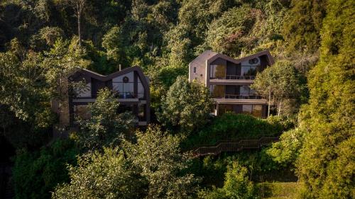 a house on the side of a hill with trees at Kavya Himalayas in Nagarkot