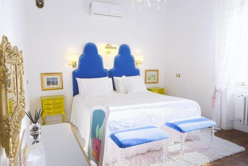 a bedroom with a bed with blue covers and two chairs at VILLA TOJI luxury private in Bracciano
