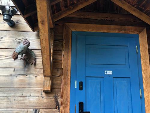 Una puerta de entrada de una cabaña de troncos con una puerta azul. en Apartamenty Ptasi Przylądek, en Mrągowo
