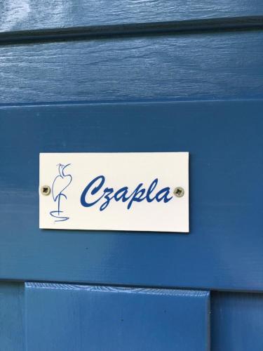 Una caja de madera azul con un cartel en ella en Apartamenty Ptasi Przylądek, en Mrągowo