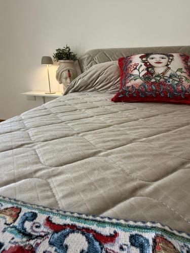 a bed with a blanket and a pillow on it at Casa Marconi duplex avec terrasse in Aragona