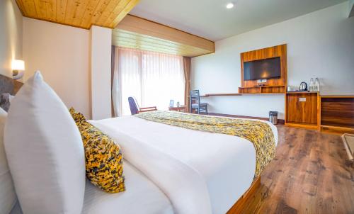 a hotel room with a bed and a television at Sumitel Pelling in Pelling