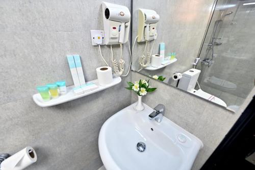 a bathroom with a sink and a mirror at Ewan Ajman Suites Hotel in Ajman 