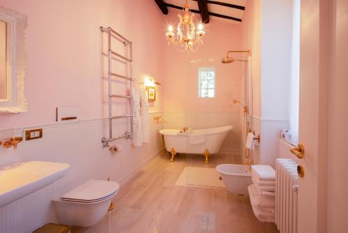 a bathroom with two toilets and a tub and a sink at VILLA TOJI luxury private in Bracciano