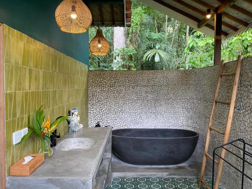 a bathroom with a large tub and a ladder at Darmada Eco Resort in Sidemen