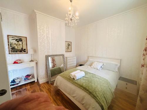 a bedroom with a bed with a mirror and a chandelier at 3-Bedroom Blue Mountains Hideaway in Central Katoomba in Katoomba