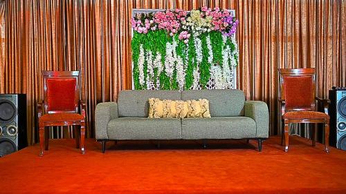 a couch in a room with a painting of flowers at Ewan Ajman Suites Hotel in Ajman 