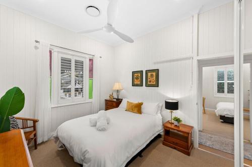 Un dormitorio blanco con una cama y dos ventanas. en Parkside Haven, en Toowoomba