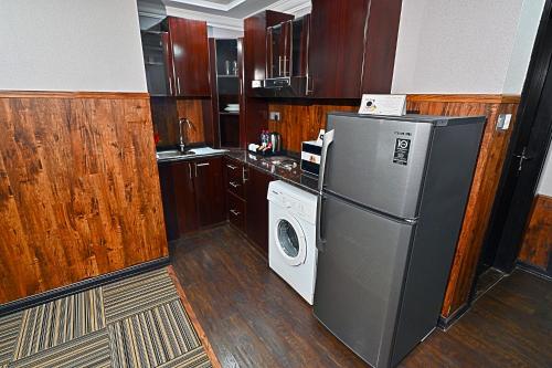 a kitchen with a refrigerator and a washing machine at Ewan Ajman Suites Hotel in Ajman 