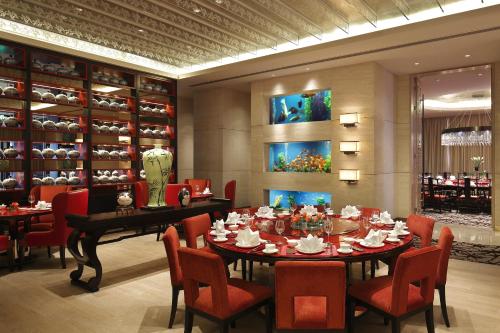a dining room with a table and chairs and a room with vases at The Azure Ningbo, Vignette Collection in Ningbo