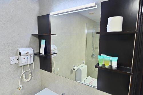 a bathroom with a large mirror and a sink at Ewan Ajman Suites Hotel in Ajman 