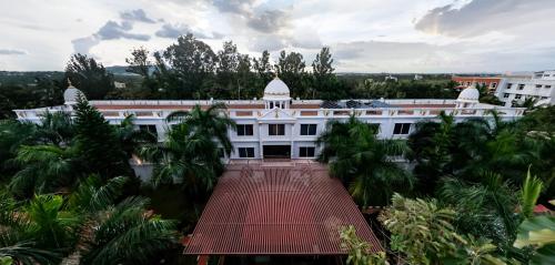 an aerial view of a white building with palm trees at Jal Mahal Resort and Spa in Mysore