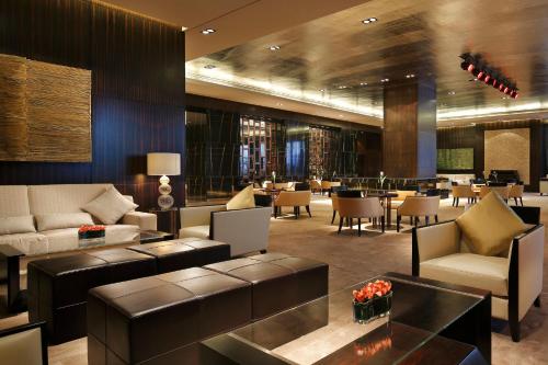 a lobby with couches and tables and a restaurant at The Azure Ningbo, Vignette Collection in Ningbo