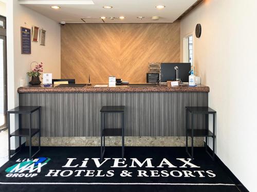 a lobby with a bar with a hawaiian hotellords and resorts sign at Hotel LiVEMAX Tendo in Tendo