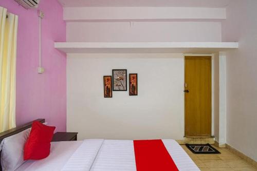a bedroom with a bed with a red and white blanket at Hotel O Purple Inn Bahadalpur Railway Station in Bhubaneshwar