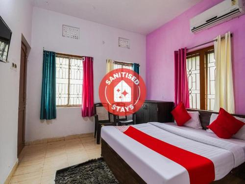 a bedroom with a large bed in a room with pink at Hotel O Purple Inn Bahadalpur Railway Station in Bhubaneshwar