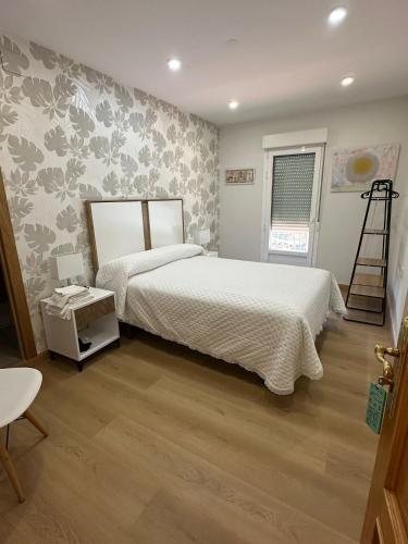 a bedroom with a large bed and a wooden floor at Hostal Monica in Cilleruelo de Bezana