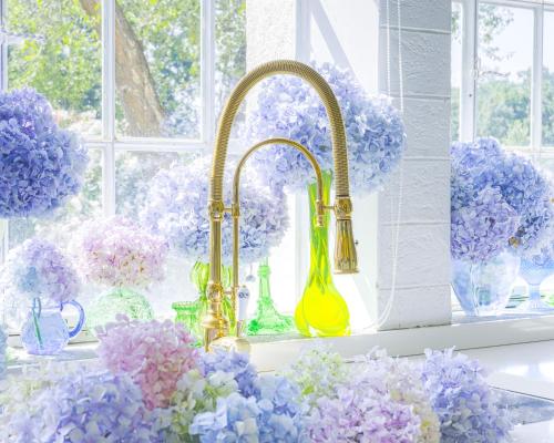 a kitchen counter with vases of flowers and a sink at VILLA TOJI luxury private in Bracciano