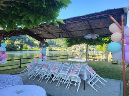 a group of white chairs and a table with balloons at Kamp kućica trokrevetna in Crnča