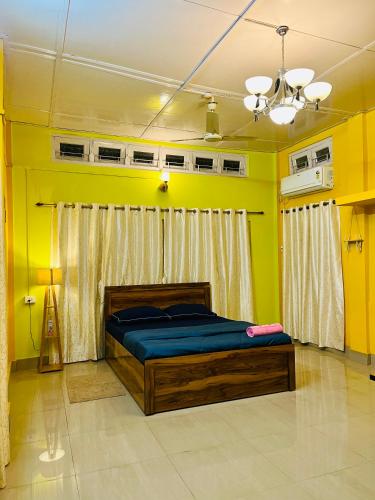 a bedroom with a bed in a yellow room at Bloom homestay in Guwahati