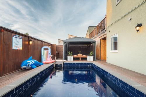 einen Pool im Hinterhof mit einem Haus in der Unterkunft Jeju Palm Spa Pool Villa in Jeju-do