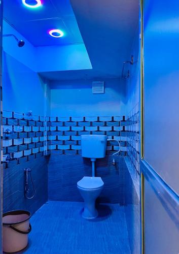 a bathroom with a toilet and a blue light at Bloom homestay in Guwahati
